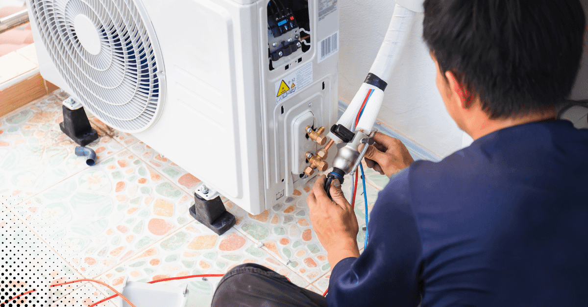 HVAC technician working on air conditioning unit installation.