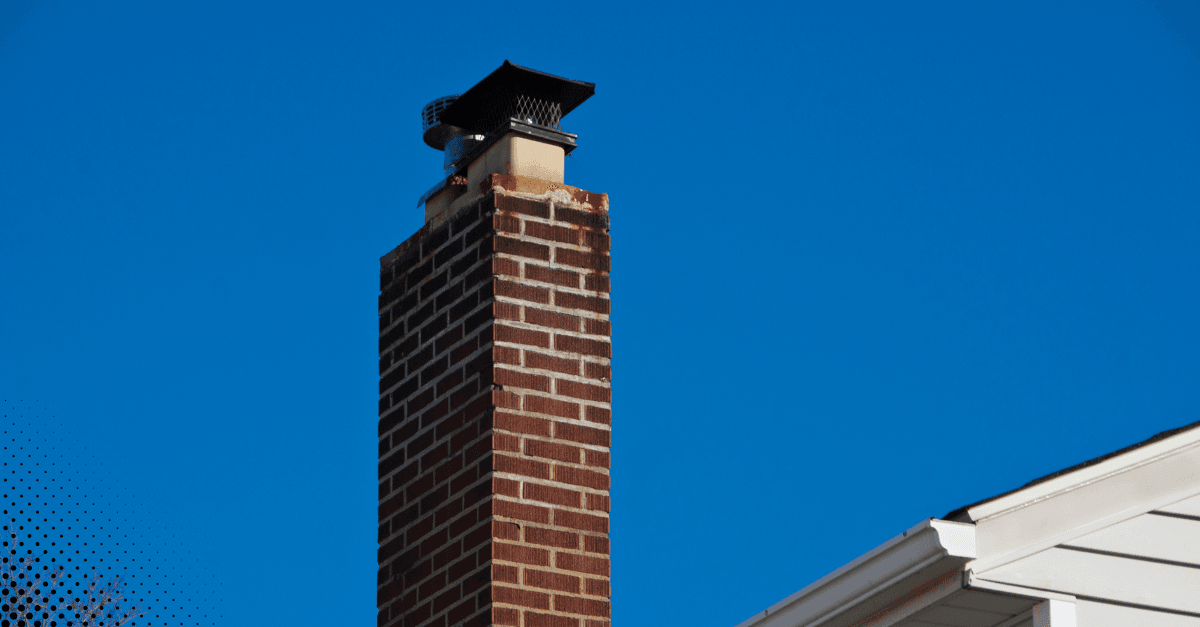 Brick chimney with a chimney cap against a blue sky