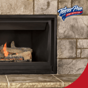 Close-up of a lit gas fireplace with glowing logs inside a stone-clad fireplace.