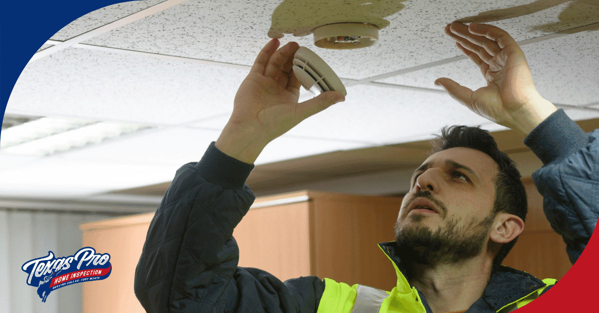 Inspector testing a smoke detector on the ceiling.