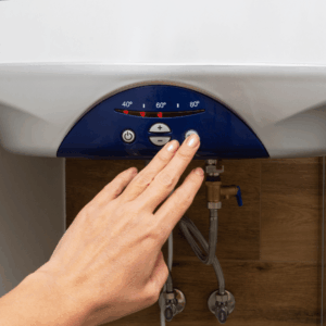 Hand adjusting the temperature on a water heater.