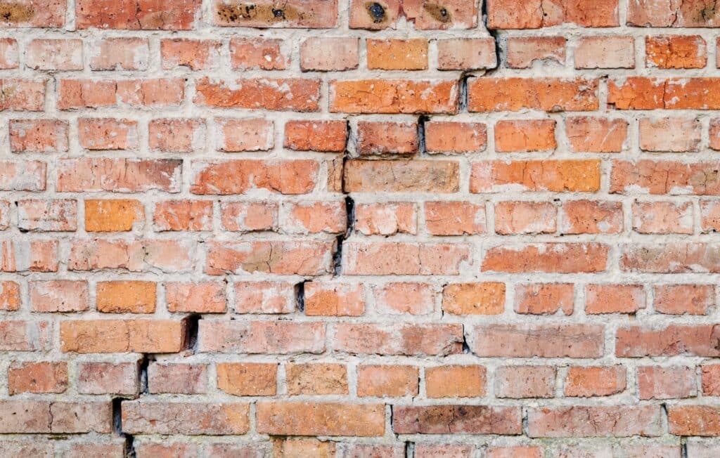 Cracked exterior brick masonry showing visible indicators of potential foundation movement during a home inspection in Fort Worth, TX